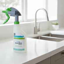 Spray bottle labeled 'Samba Shine' on a kitchen counter with a sink in the background.